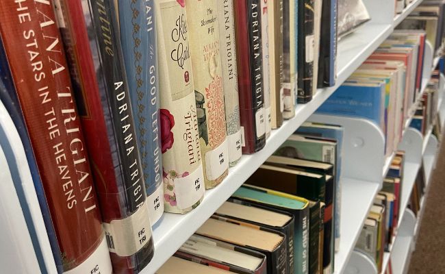 close up of a book shelf with multiple books
